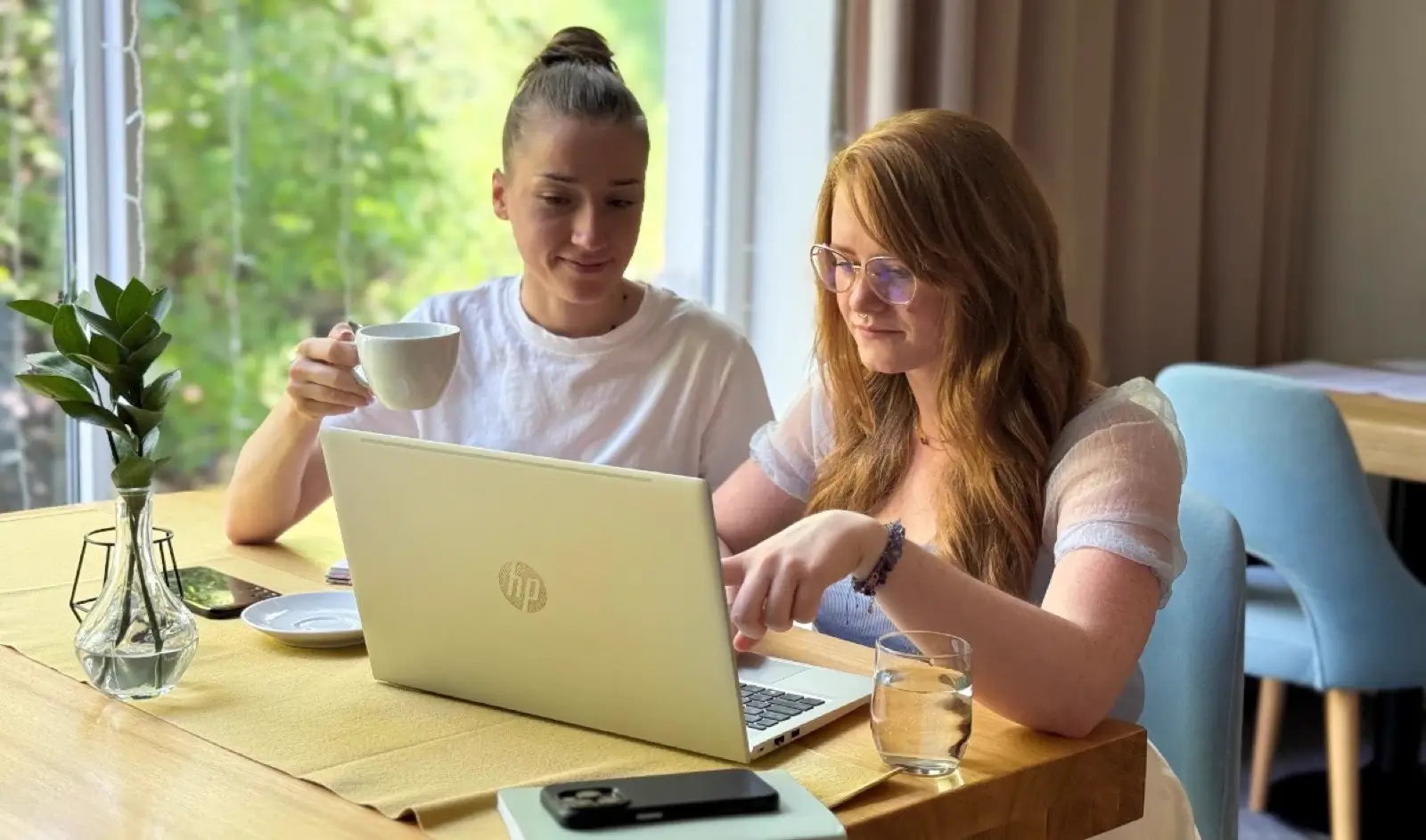 Dwie osoby z zespołu Holimo planują program wyjazdu przy laptopie